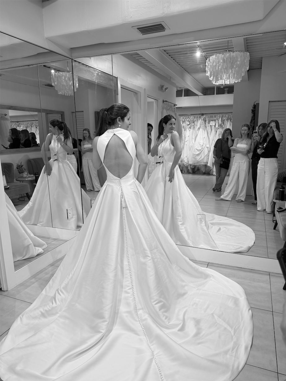 Una novia probándose un vestido frente al espejo en una boutique