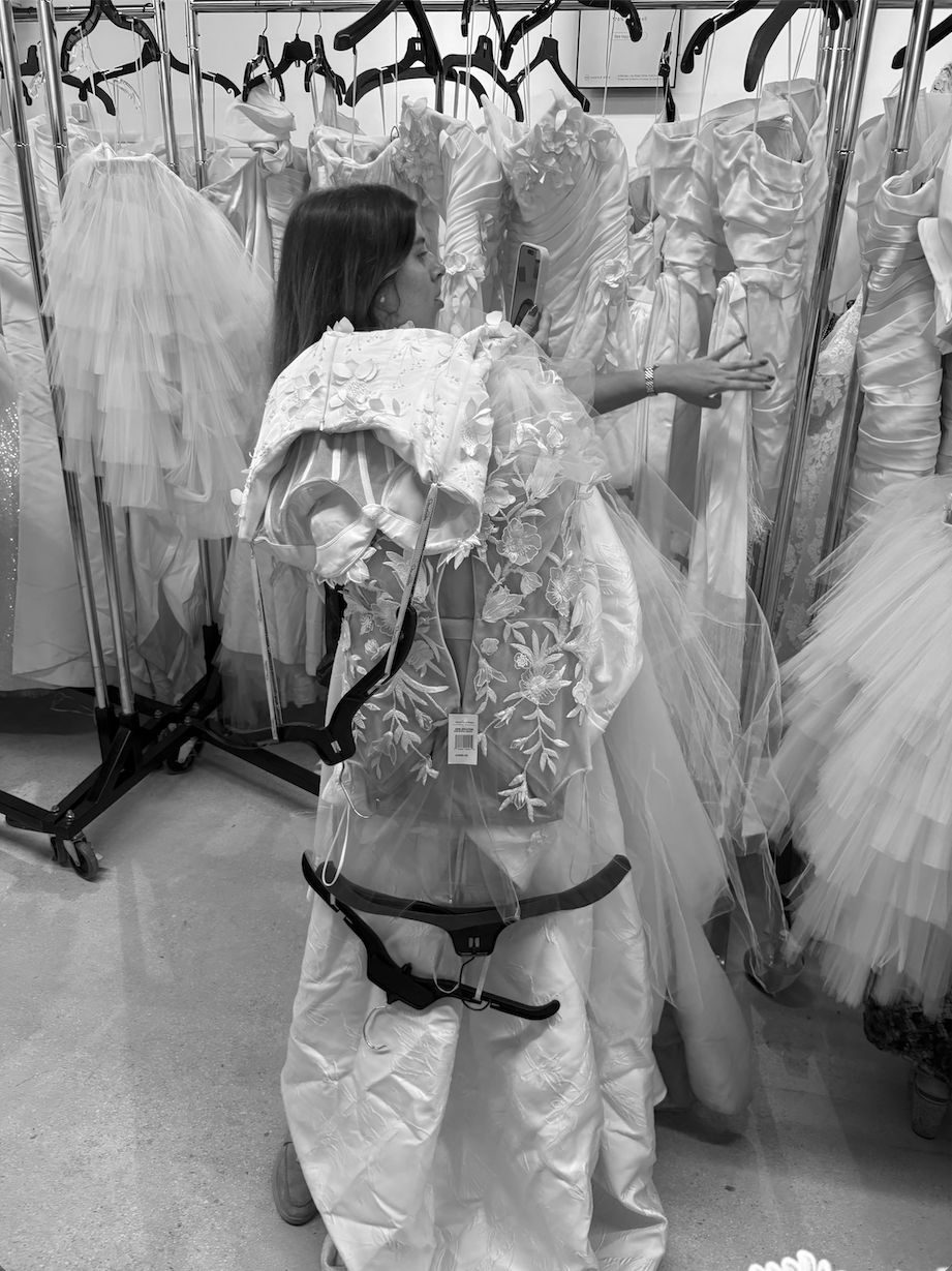 Lia cargando vestidos y tomando fotos en un sample sale